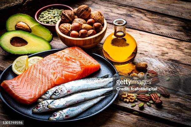 alimentos con alto contenido de grasas saludables sobre mesa de madera rústica - avocato oil fotografías e imágenes de stock