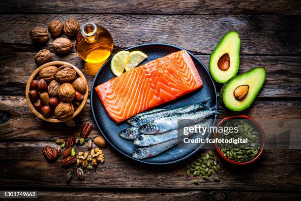 lebensmittel mit hohem gehalt an gesunden fetten auf rustikalem tisch. overheadansicht. - almond oil stock-fotos und bilder