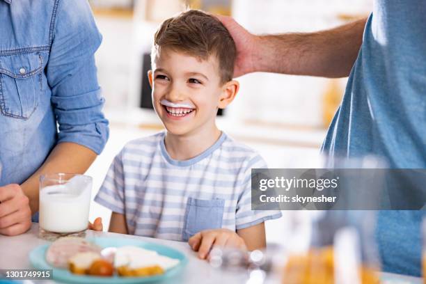 happy little boy with milk mustaches in dining room. - mother son milk imagens e fotografias de stock
