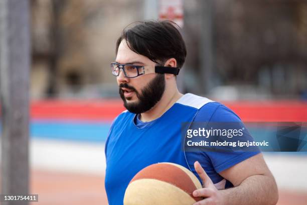 homme de poids excessif jouant le basket-ball de rue - lunettes de pilote de course photos et images de collection