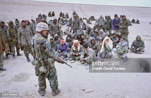 United States military personnel with their M16 rifle, guarding prisoners of war near the 5th Mobile Army Surgical Hospital, during the Gulf War, at...
