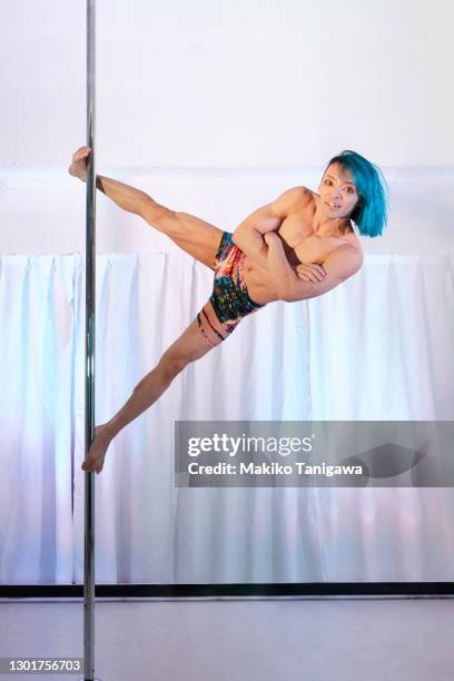 male pole dancer practicing in a pole dance studio - pole dancing stock pictures, royalty-free photos & images