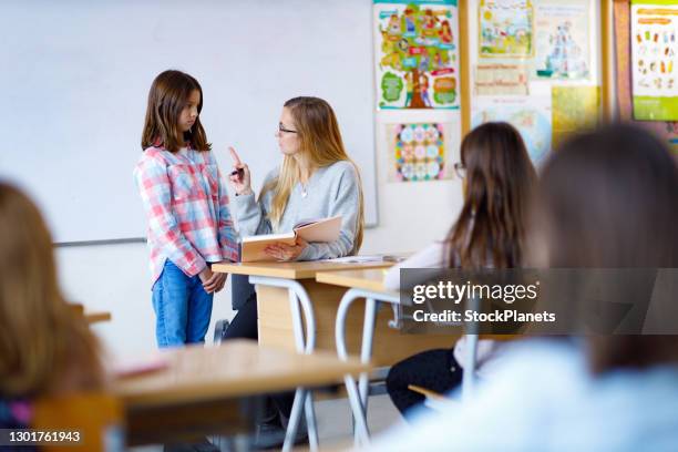 unhappy teacher pointing finger at schoolgirl in the classroom - rules and regulations stock pictures, royalty-free photos & images