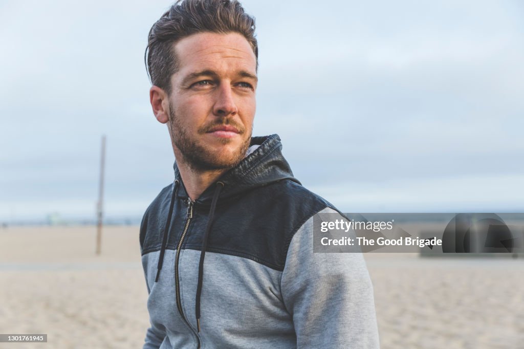 Portrait of handsome man standing at beach