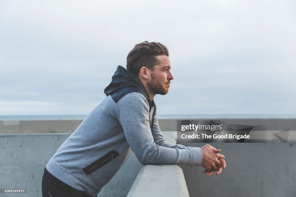 Man leaning on wall looking out to sea