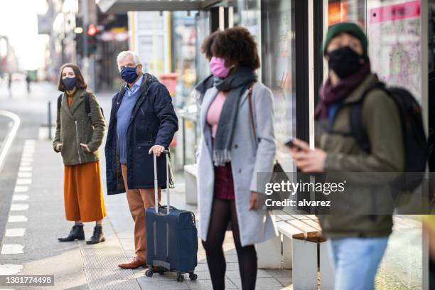 commuter waiting at tram station during pandemic - waiting bus stock pictures, royalty-free photos & images