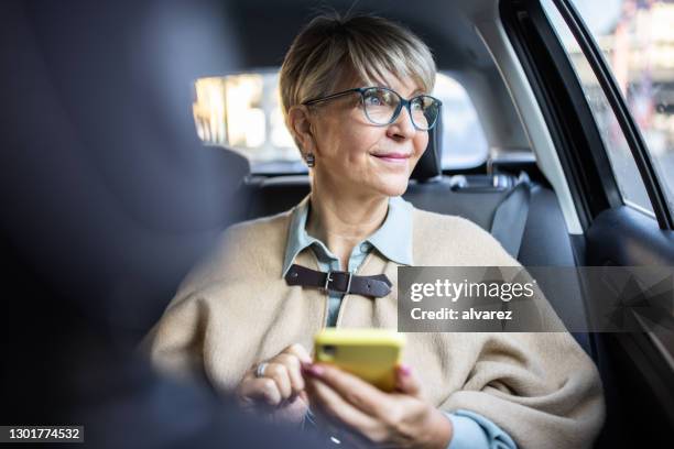 donna anziana che viaggia in città in taxi - passenger seat foto e immagini stock