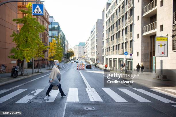 seniorin in gesichtsmaske mit zebrastreifen - zebrastreifen stock-fotos und bilder