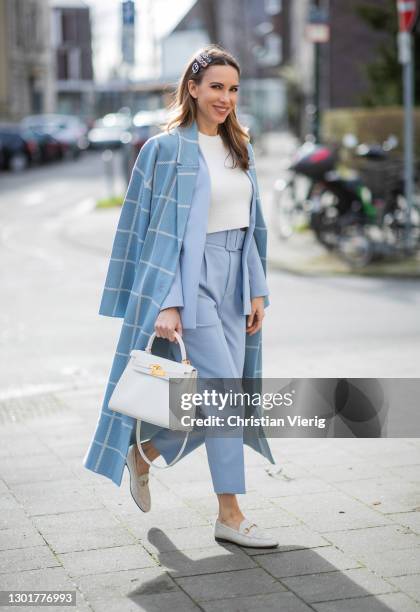 Alexandra Lapp is seen wearing ZARA oversized checked coat in light blue, ZARA blazer in pastel blue, ZARA knit jumper in white, ZARA pants in pastel...