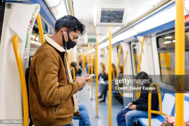 ethnic man in mask in train in subway - máscara de proteção imagens e fotografias de stock