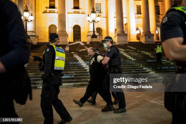 Protester is detained by the Police at an anti lockdown protest in front of Parliament House, following the announcement of the lockdown on February...