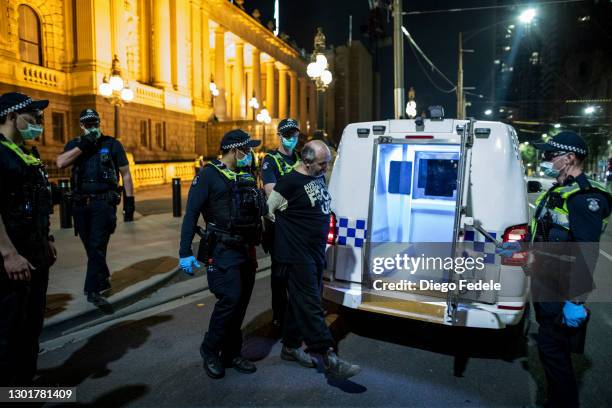 Protester is detained by the Police at an anti lockdown protest in front of Parliament House, following the announcement of the lockdown on February...