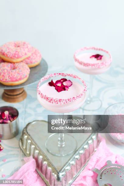 rosa erdbeercreme cocktail drink mit zuckerstreuseln und rosenblättern - soft drink stock-fotos und bilder