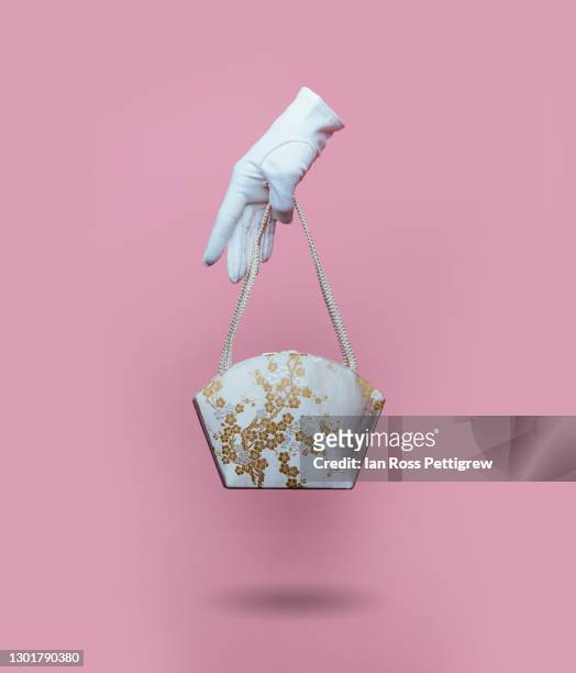 woman's floating gloved hand holding purse - white glove stock pictures, royalty-free photos & images