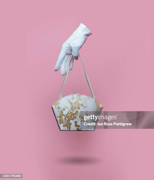 woman's floating gloved hand holding purse - glove hand stock pictures, royalty-free photos & images