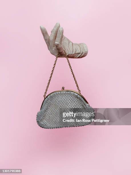 woman's floating gloved hand holding purse - handtasche stock-fotos und bilder