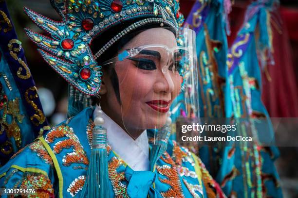 Chinese opera troupe members wear face shields as protection from COVID-19 during a performance at Lhong 1919 on February 12, 2021 in Bangkok,...