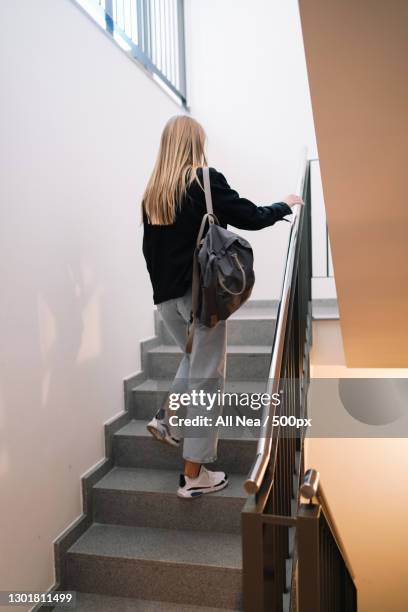 caucasian young adult woman ascending stairs at home,spain - spostarsi verso lalto foto e immagini stock