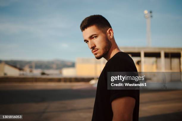 angry man staring while standing outdoors - guy staring stock pictures, royalty-free photos & images