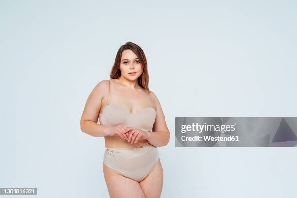 young woman in lingerie staring while standing in studio - beautiful voluptuous women 個照片及圖片檔