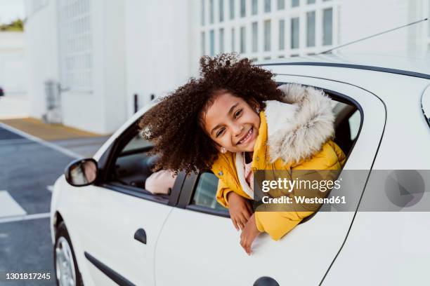 cheerful girl peeking through window while traveling in car - girl short hair stock pictures, royalty-free photos & images