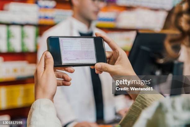 hand of customer using smart phone for prescription in chemist store - apotheke rezept stock-fotos und bilder