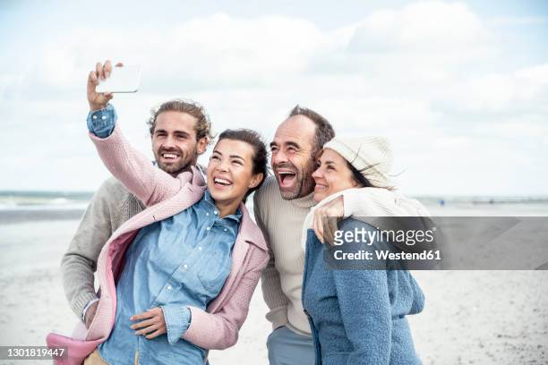 group of friends taking selfie at beach - quartet stock pictures, royalty-free photos & images