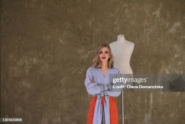beautiful stylish girl stands near a mannequin - blusa cor de laranja imagens e fotografias de stock