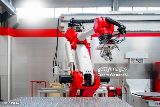 red and white automatic welding robot in factory - automatic stock pictures, royalty-free photos & images