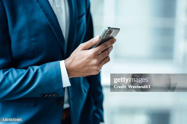 male entrepreneur using smart phone at office - suit hand stock-fotos und bilder