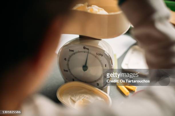 weighting butter on an analog kitchen scale - mass unit of measurement stock pictures, royalty-free photos & images