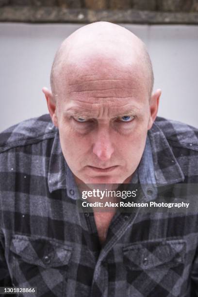 head shot of a bald man in his fifties pulling a moody face - ugly bald man stock pictures, royalty-free photos & images