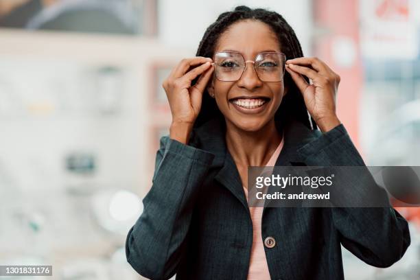 een vrouw die glazen draagt - oogmeetkunde stockfoto's en -beelden