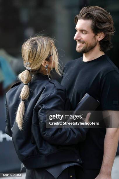 Influencer Gitta Banko wearing a low bubble ponytail hairstyle, a black bomber jacket by Saint Laurent, silver crystal heart 'YSL' earrings by Saint...