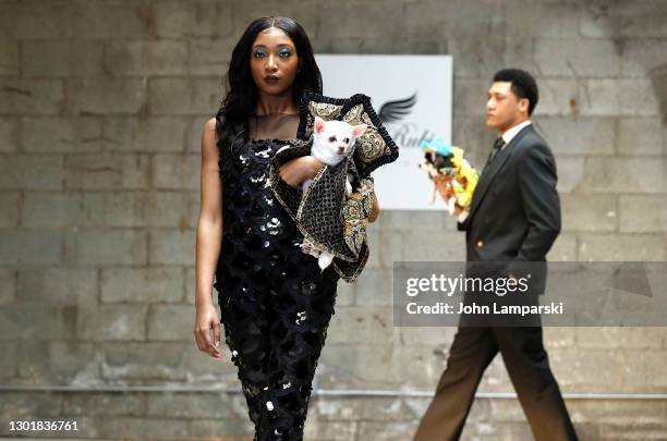 Models walk the runway with a dog during Anthony Rubio's Women's Wear Canine Couture show during New York Fashion Week at Ideal Glass Studios on...