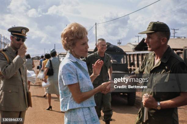 United States First Lady Pat Nixon , wearing a blue-and-white two-piece skirt suit, meeting military personnel during a visit to the 24th Evacuation...