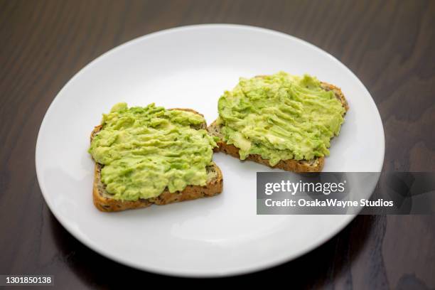 smashed green avocado spread on toast - avocado toast stock pictures, royalty-free photos & images