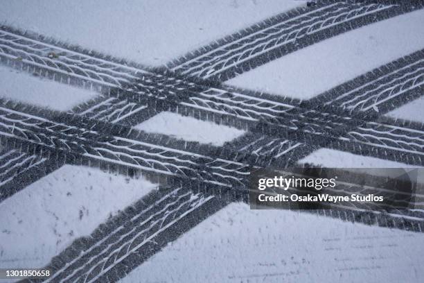 tyre tracks in thin layer of snow - tyre track stock pictures, royalty-free photos & images