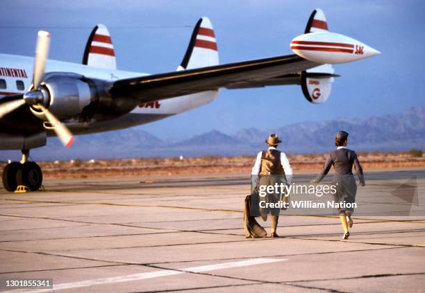 American actor, playwright, author, screenwriter, and director Sam Shepard and American film actress Traci Lind run to the plane during a scene on...