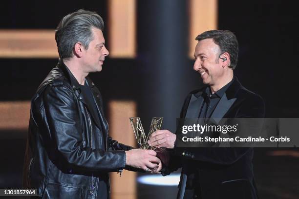 Benjamin Biolay receives the ‘best male artist of the year’ award from Stephane Bern during the 36th "Victoires De La Musique" Award Ceremony at La...