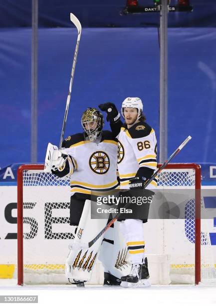 Jaroslav Halak of the Boston Bruins is congratulated by teammates Kevan Miller after the win over the New York Rangers at Madison Square Garden on...