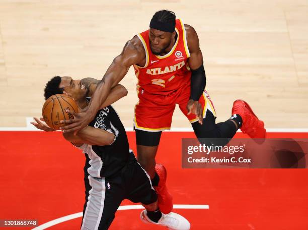 Bruno Fernando of the Atlanta Hawks fouls Keita Bates-Diop of the San Antonio Spurs during the second half at State Farm Arena on February 12, 2021...