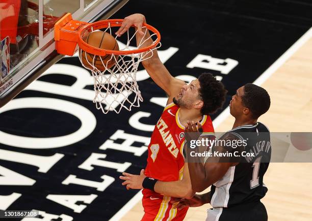 Skylar Mays of the Atlanta Hawks dunks against Lonnie Walker IV of the San Antonio Spurs during the second half at State Farm Arena on February 12,...