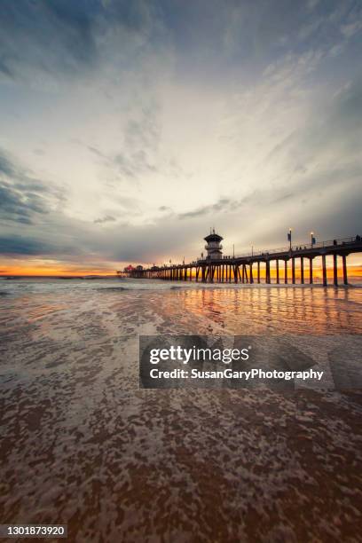 incoming tidal flow during sunset at the pier - huntington beach stock-fotos und bilder