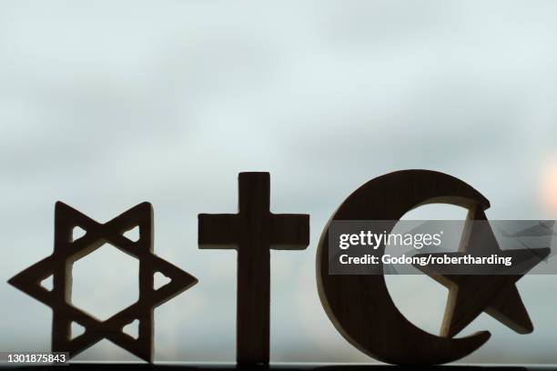 christianity, islam, judaism, the three monotheistic religions in symbols of jewish star, christian cross and islamic crescent, france, europe - christianisme photos et images de collection