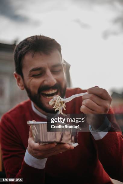 man smile beim essen im freien - pasta geniessen stock-fotos und bilder