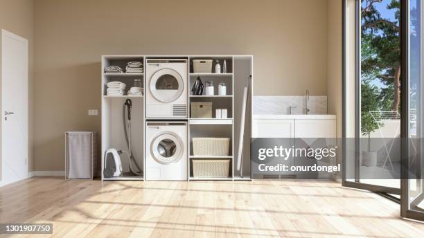 lavanderia con parete beige e pavimento in parquet con lavatrice, asciugatrice, cestino della biancheria e asciugamani piegati nell'armadio. - aspirapolvere foto e immagini stock