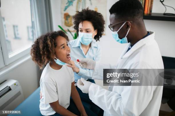 high angle view of a little african american girl doing a swab test - black people wearing masks stock pictures, royalty-free photos & images