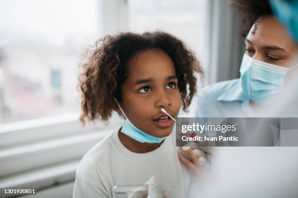 sluit omhoog van een weinig afrikaans amerikaans meisje dat een swabtest doet - cotton swab stockfoto's en -beelden