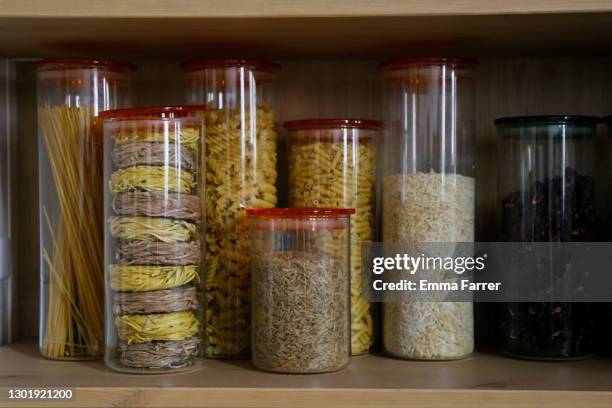 jars of dried food on a wooden shelf - voorraadkast stockfoto's en -beelden